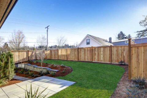 Sloped backyard surrounded by wooden fence Luxury New construction
